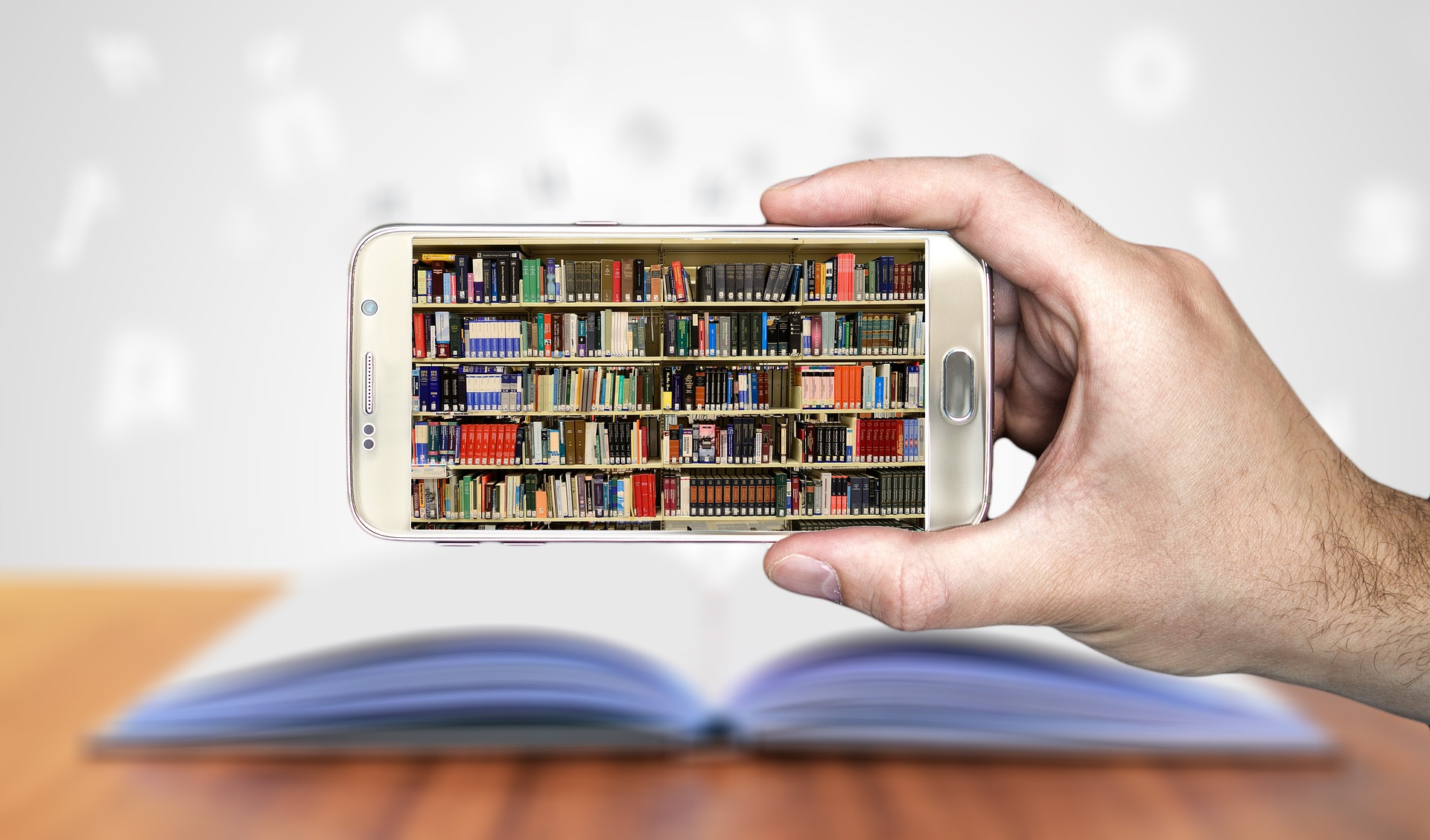 Picture of a hand holding a smart phone that is displaying library shelves filled with books.